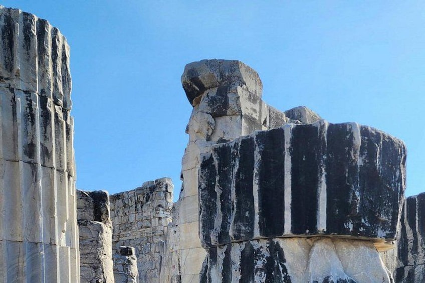 Ancient stone ruins with weathered columns and large rock formations. 2