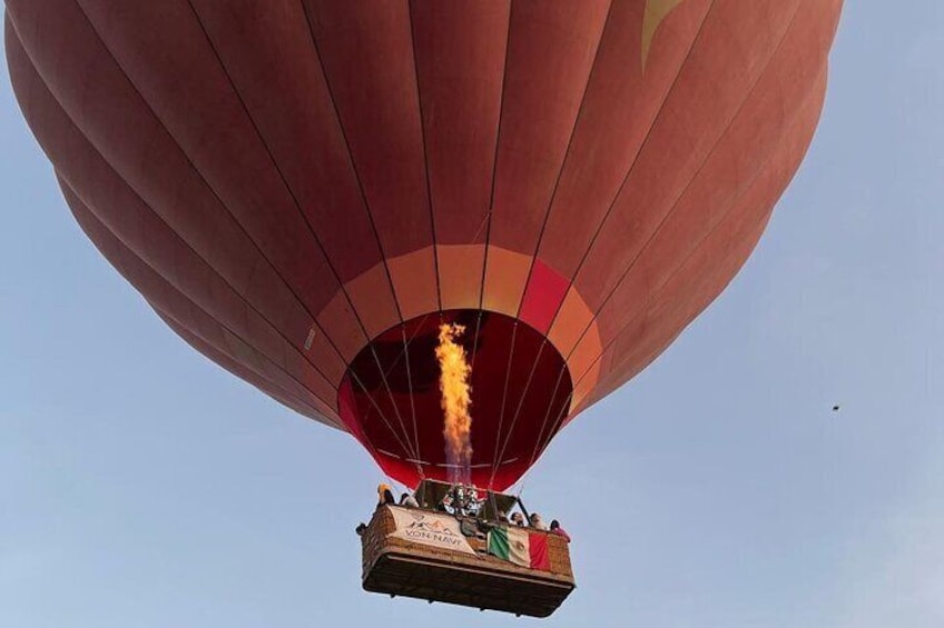 A hot air balloon with a visible flame at its base, a basket with people, and the text "VON NAVY" on the basket. 3