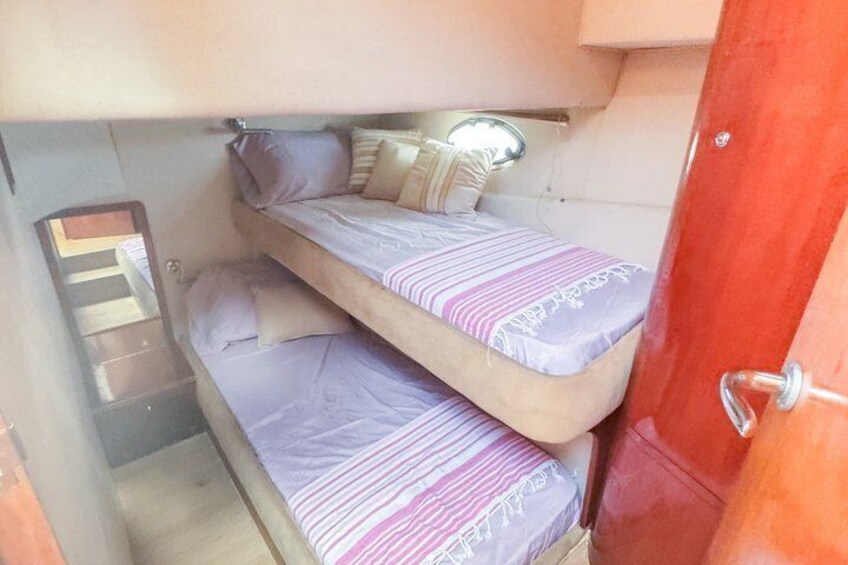 A small, enclosed space with bunk beds, a mirror, and a door. 5