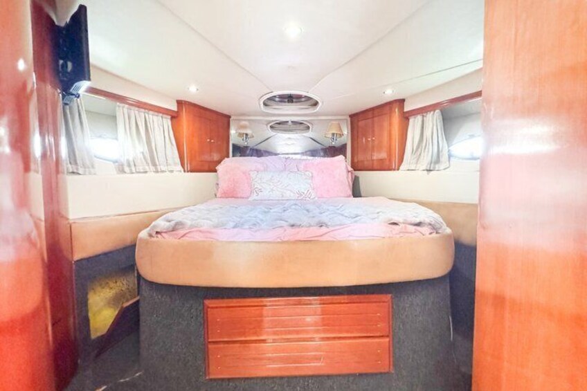 A bedroom with a bed, curtains, and a wooden headboard. 3
