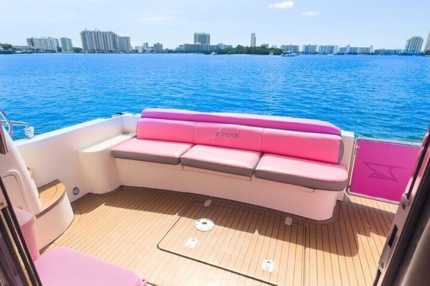 A boat with a pink cushioned bench and a wooden deck. 2