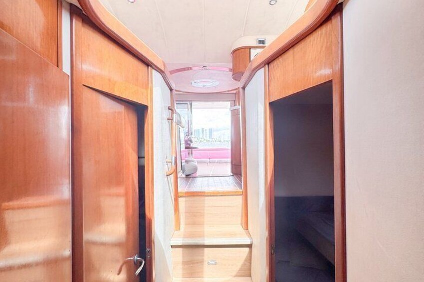 A narrow corridor with wooden doors and a small window at the end. 4