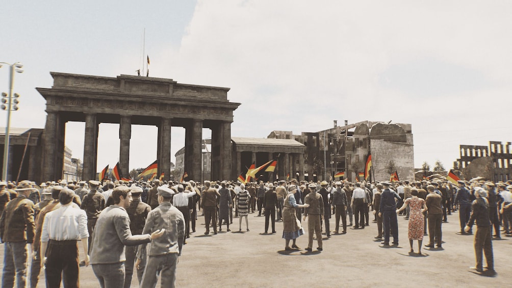 A large crowd of people in front of the Brandenburg Gate, with many holding flags. 2