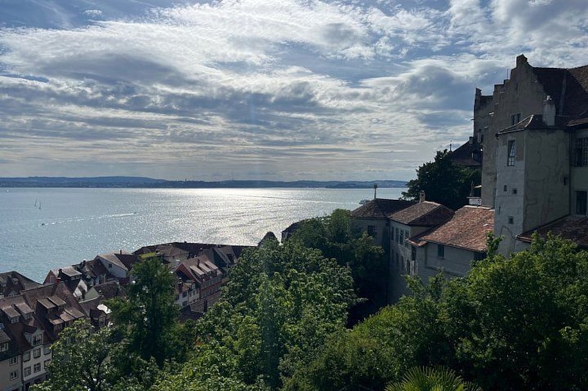 A coastal town with buildings, a body of water, and a cloudy sky. 2