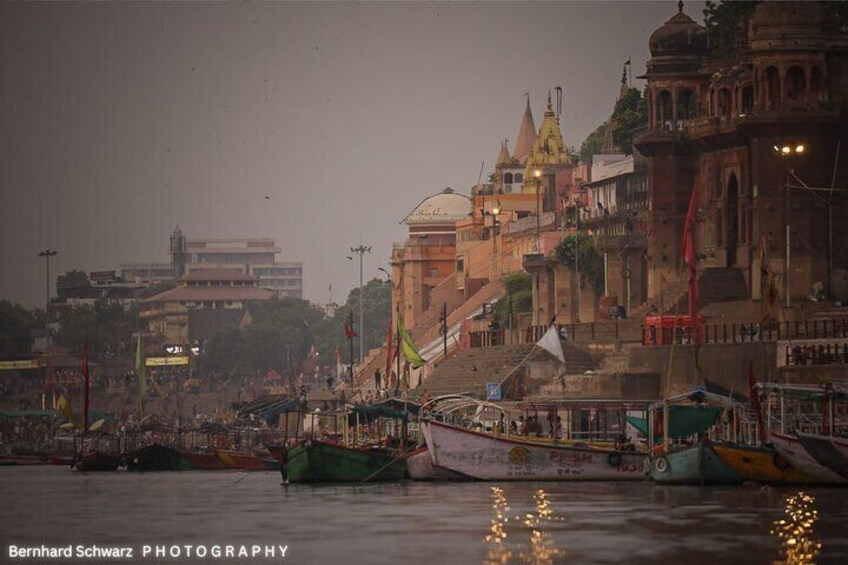 A riverside scene with boats docked, a bridge, and historic buildings. 4