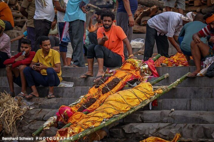 A person lying on the steps, covered with a yellow cloth, surrounded by onlookers. 5
