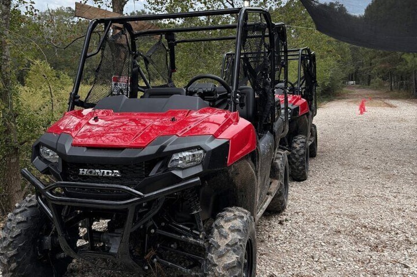 A red and black Honda ATV on a gravel path with trees in the background. 4