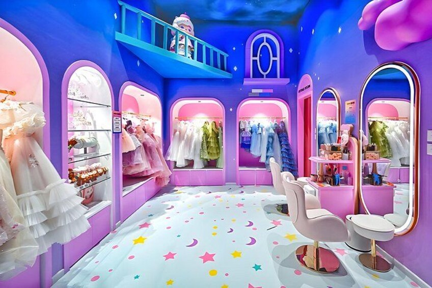 A colorful boutique with pink and purple walls, a star-patterned floor, and various clothing items on display. 5