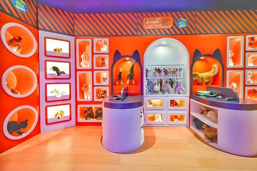 A brightly lit room with orange walls, shelves with plush toys, and a 'groomer' sign. 4