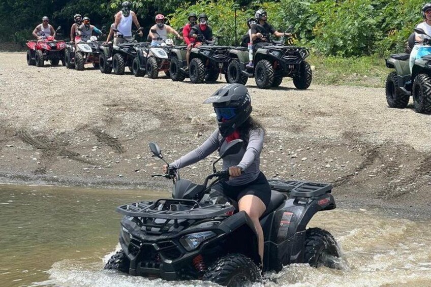 Eine Person fährt mit einem Geländefahrzeug durch flaches Wasser. 5