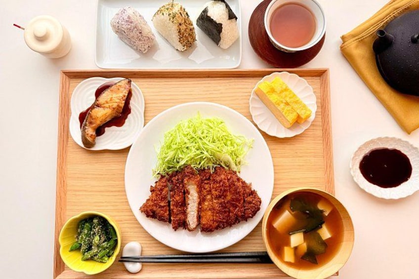 En måltid med olika japanska rätter, inklusive en tallrik med skivad kött, grönsaker och en skål soppa. 1