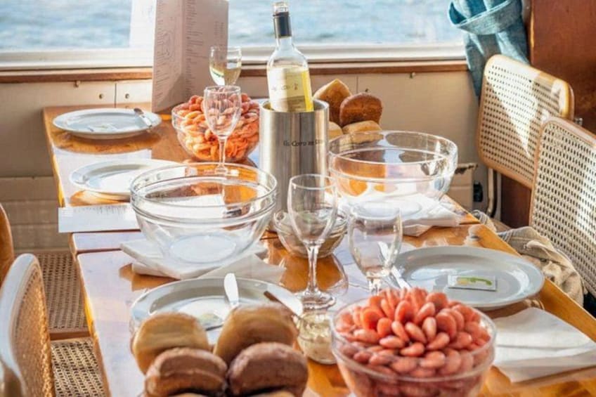 A table set for a meal with plates, bowls, a bottle, and glasses. 5