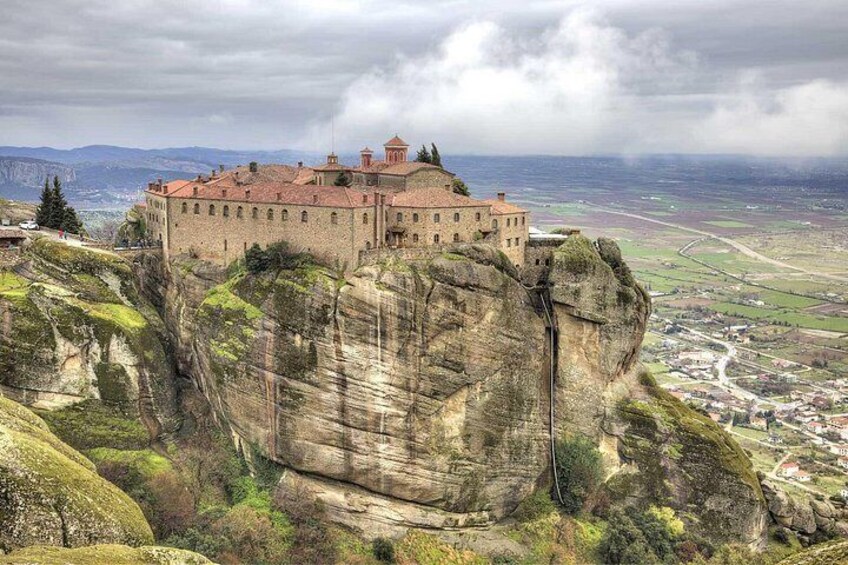 A castle on a rocky cliff overlooking a valley. 1