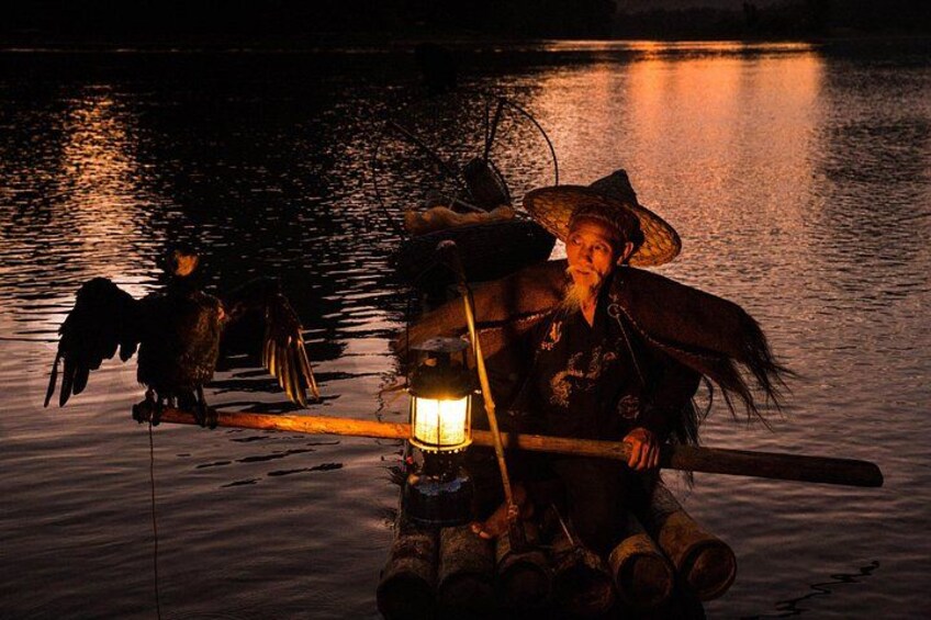 A person on a boat at night with a lantern, birds flying, and calm water. 2