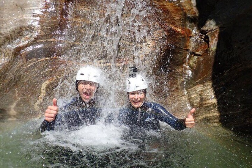 Two people in a cave with water splashing around them. 3
