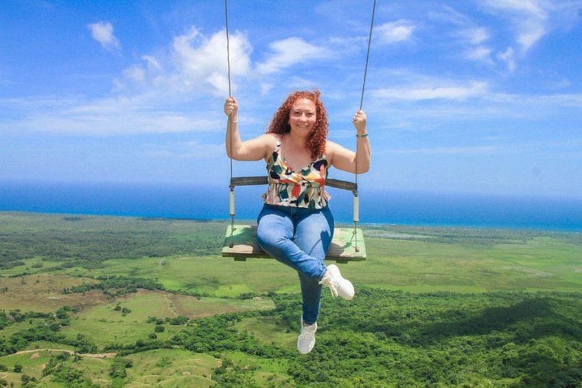 A person on a swing overlooking a vast landscape. 5