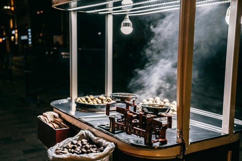 A food cart with a steam vent, a bowl of mushrooms, and a basket of bread. 4