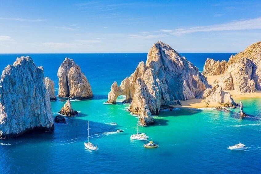 A coastal landscape with rocky formations and clear turquoise waters. 5