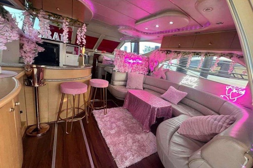A pink-themed interior with a bar area, seating, and decorative elements. 4