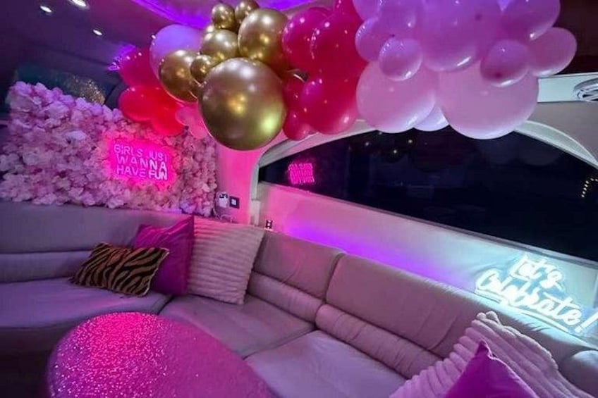 A pink and gold decorated room with a neon sign that reads 'Girls Just Wanna Have Fun.' 2