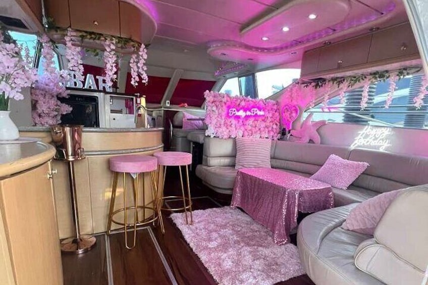 A pink-themed interior with a bar area, seating, and decorative flowers. 2