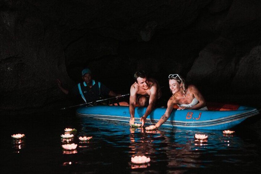 A group of people in a blue boat on water with lotus flowers. 4