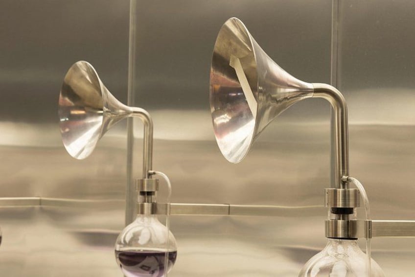 A bathroom with two chrome-finished, curved showerheads mounted on a wall. 3