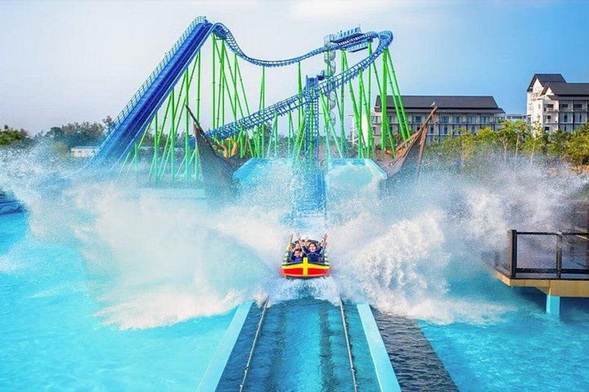 Eine Wasserattraktion mit Achterbahn, Schwimmbecken und einem Gebäude im Hintergrund. 4