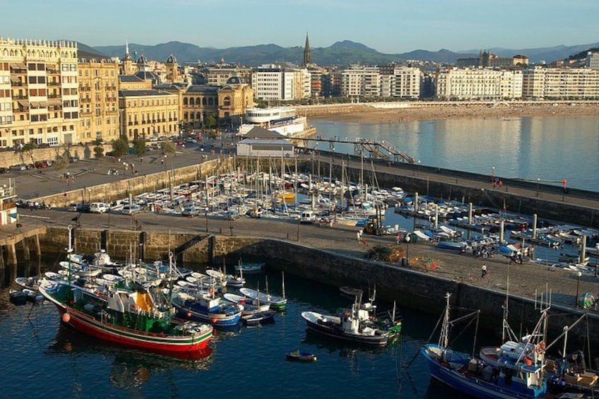 A harbor with boats docked, a waterfront promenade, and historic buildings in the background. 4