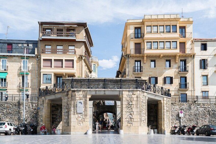 A stone archway with buildings on either side. 5