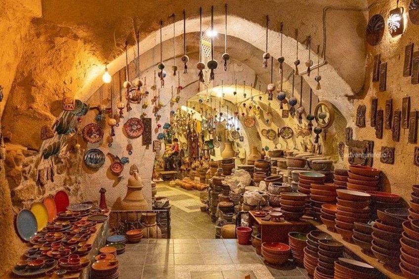 A pottery shop with shelves of colorful ceramic dishes and hanging decorations. 3