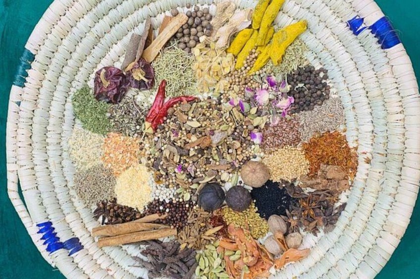 A circular woven basket filled with various dried herbs and spices. 3