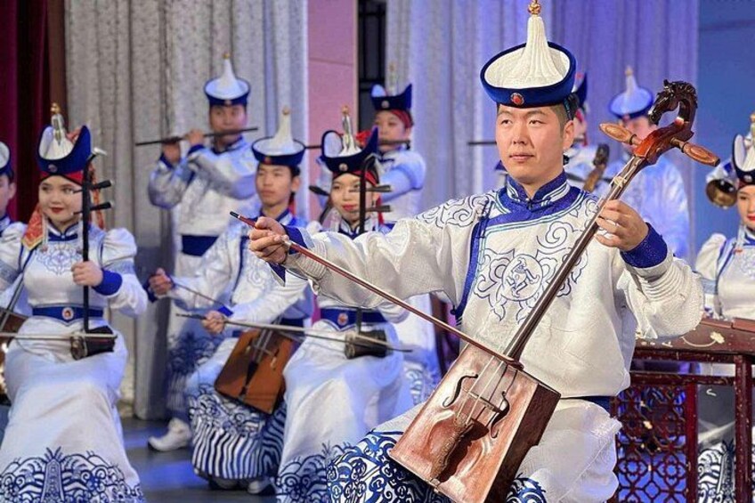 A group of musicians in traditional attire performing with string instruments. 4
