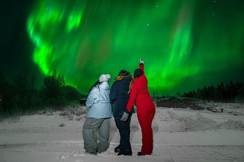 Drie mensen kijken naar het noorderlicht. 1