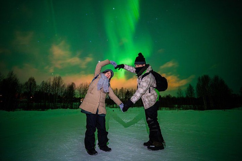 Twee personen schaatsen onder een groen poollicht. 5