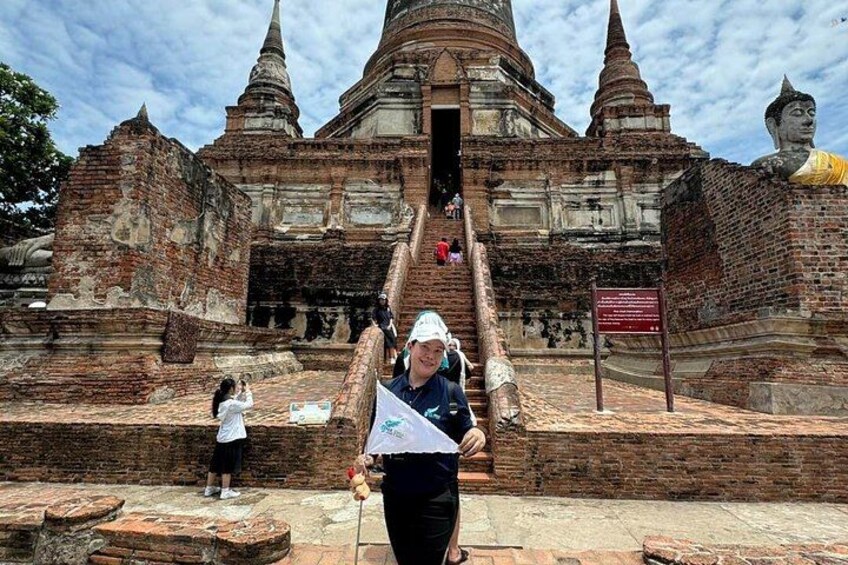 Ein uralter Tempel mit einer großen Buddha-Statue, einer Treppe, die zum Eingang führt, und einer Person, die ein Foto macht. 4