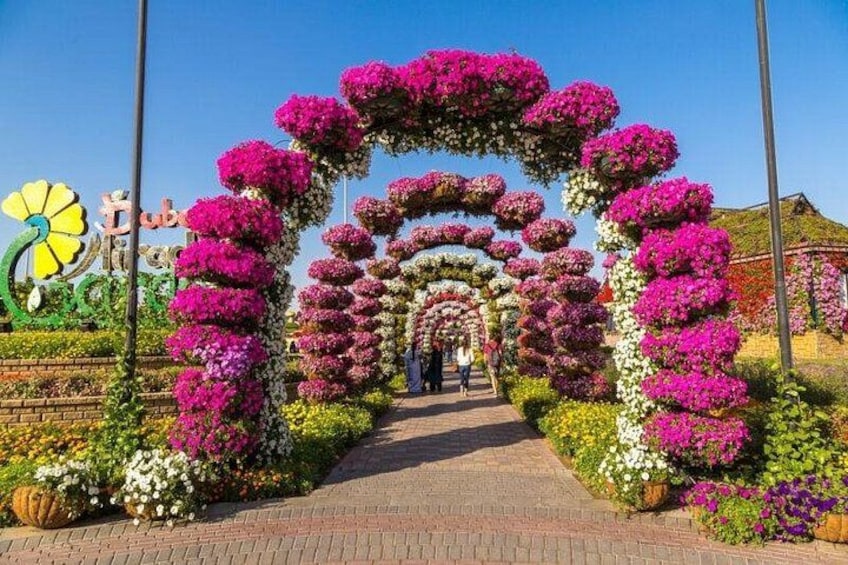 En blomsterpyntet buegang med en sti der går igennem den. 1