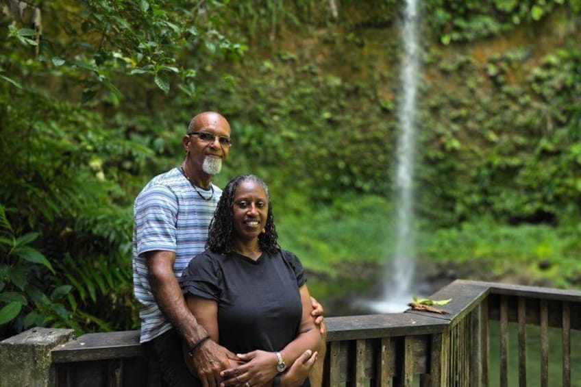 Un couple se tient près d’une cascade, dans une forêt luxuriante et verdoyante. 4