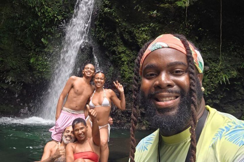 Une cascade, une végétation luxuriante et des personnes profitant de ce cadre naturel. 1