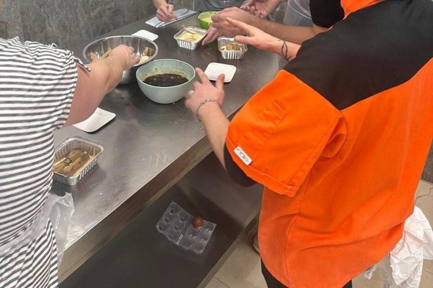 Personale betjener mad ved et buffetbord med skåle og fade. 3