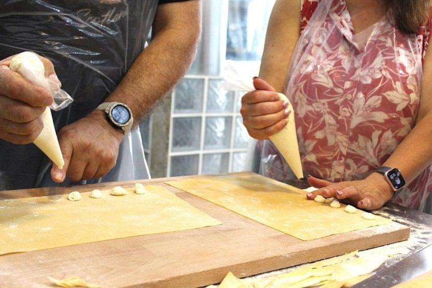 Two people using piping bags to decorate dough with a piping bag. 3