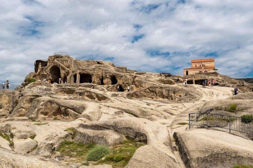 A rocky landscape with ancient ruins and a small building. 2