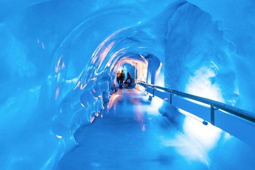 An ice tunnel with a metal railing. 3