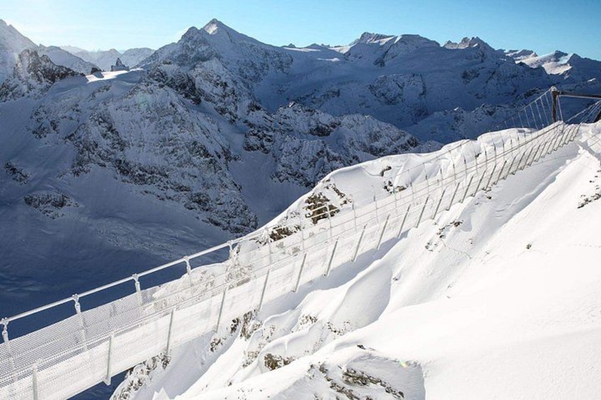 A snow-covered mountain ridge with a metal railing. 2