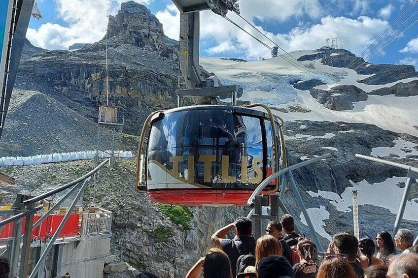 A cable car with passengers, a mountainous landscape, and a glacier. 4