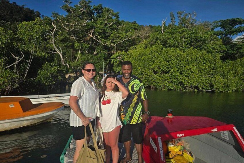 Three people on a boat near a mangrove forest. 2
