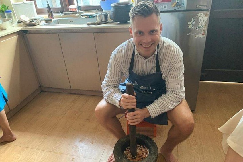 A person using a mortar and pestle in a kitchen. 5