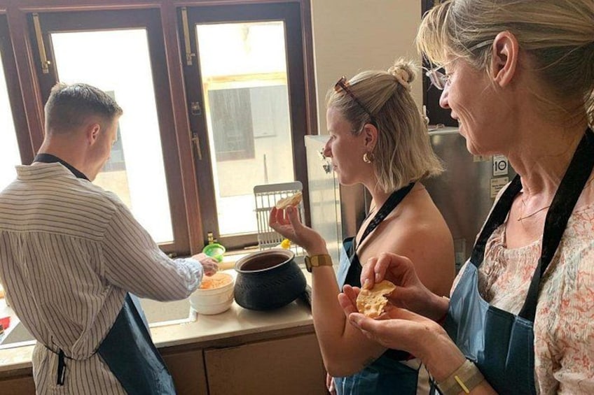 A person serving food to two others at a table. 4