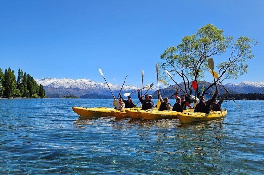 Un grupo de personas haciendo kayak en un lago, con montañas al fondo. 1