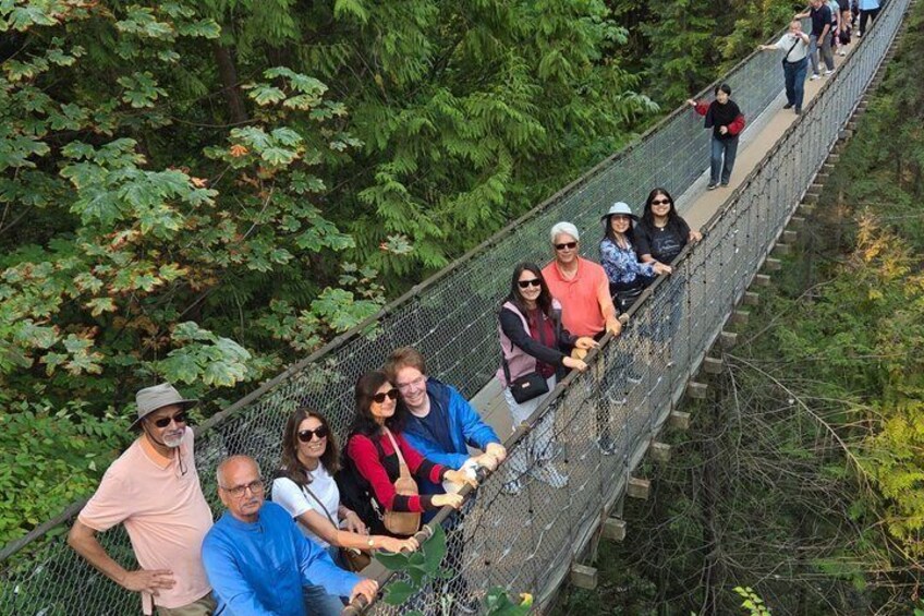 Un groupe de personnes se trouve sur un pont suspendu, entouré d’une forêt dense. 5
